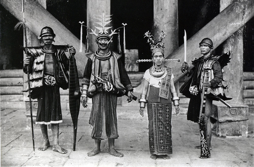 Noblemen and woman in front of house South Nias
